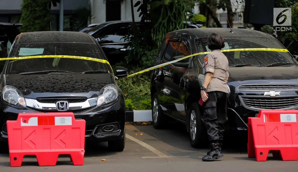 Petugas memasang garis polisi pada puluhan barang bukti mobil yang berhasil disita saat gelar kasus di Polda Metro Jaya, Rabu (18/9/2019). Subdit 6 Ditreskrimum PMJ mengungkap kejahatan penggelapan mobil dengan barang bukti 28 kendaraan roda empat dan sejumlah tersangka. (Liputan6.com/Faizal Fanani)