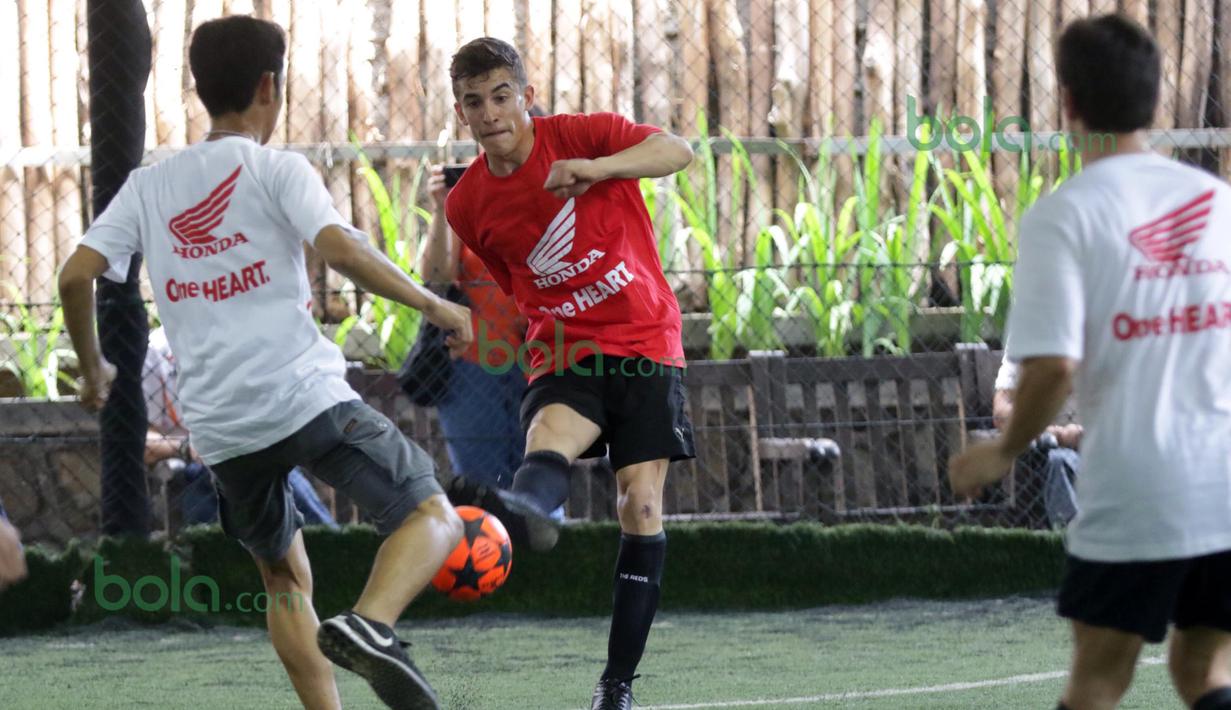 Marc Marquez (tengah) dari Tim Merah melepaskan tembakan ke arah gawang lawan  saat bermain futsal di Lapangan Futsal Kuningan Village, Jakarta, Sabtu (13/2/2016). (Bola.com/Nicklas Hanoatubun)