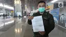 Calon penumpang dengan izin khusus perjalanan dinas menunjukan surat syarat terbang di Terminal 3 Bandara Soekarno Hatta, Tangerang, Banten, Kamis (7/5/2020). Pemerintah melalui kementerian Perhubungan membuka kembali penerbangan domestik dengan penumpang bersyarat. (Liputan6.com/Herman Zakharia)
