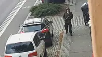 Seorang pria berjalan membawa senjata di jalanan Halle an der Saale, Halle, Jerman, Rabu (9/10/2019). Pelaku melarikan diri menggunakan mobil usai melancarkan aksinya. (Andreas Splett/ATV-Studio Halle/AFP)