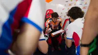 Marc Marquez tampak sangat serius berbincang dengan kru tim Repsol Honda pada tes pramusim MotoGP 2020 di Sirkuit Losail, Qatar. (Twitter/Repsol Honda)