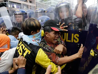 Pengunjuk rasa terlibat bentrok dengan polisi saat menggelar aksi demo di dekat Kedutaan Besar AS di Manila, Filipina (11/11). Mereka menggelar aksi untuk memprotes kunjungan Presiden AS, Donald Trump ke Filipina. (AP Photo/Aaron Favila)