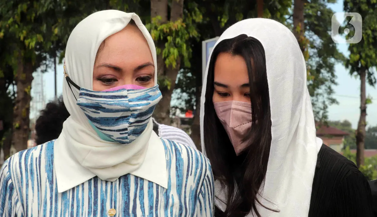 Mantan Anggota DPR Angelina Sondakh (kiri) bersama Aaliyah Massaid saat ziarah makam di TPU Jeruk Purut, Jakarta Selatan, Kamis (3/3/2022). Kedatangan Angelina Sondakh bersama kedua anaknya untuk berziarah ke makam Adjie Massaid dan bapak dari Adjie Massaid. (Liputan6.com/Herman Zakharia)