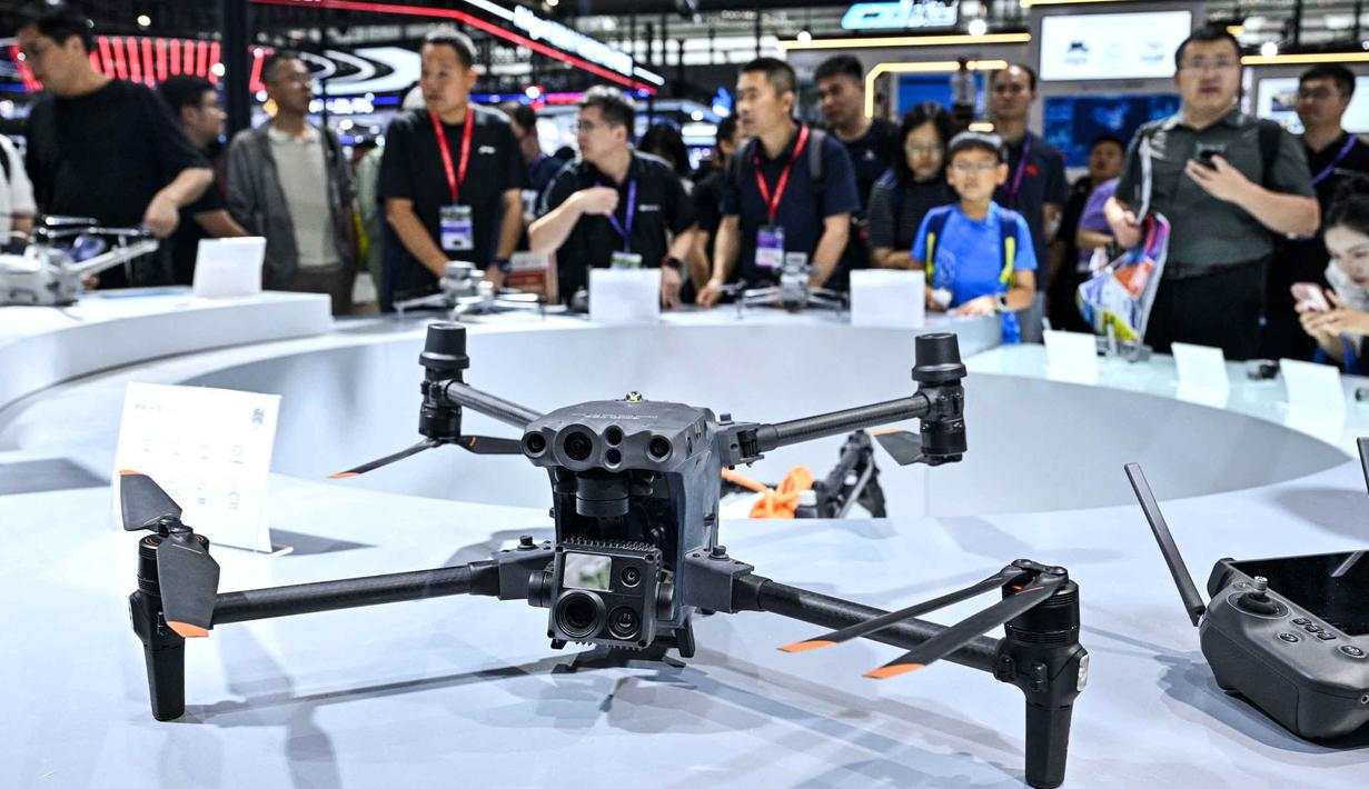 Pengunjung terlihat di stan DJI selama Drone World Congress (DWC) di Shenzhen pada 21 Mei 2026. (HECTOR RETAMAL/AFP)