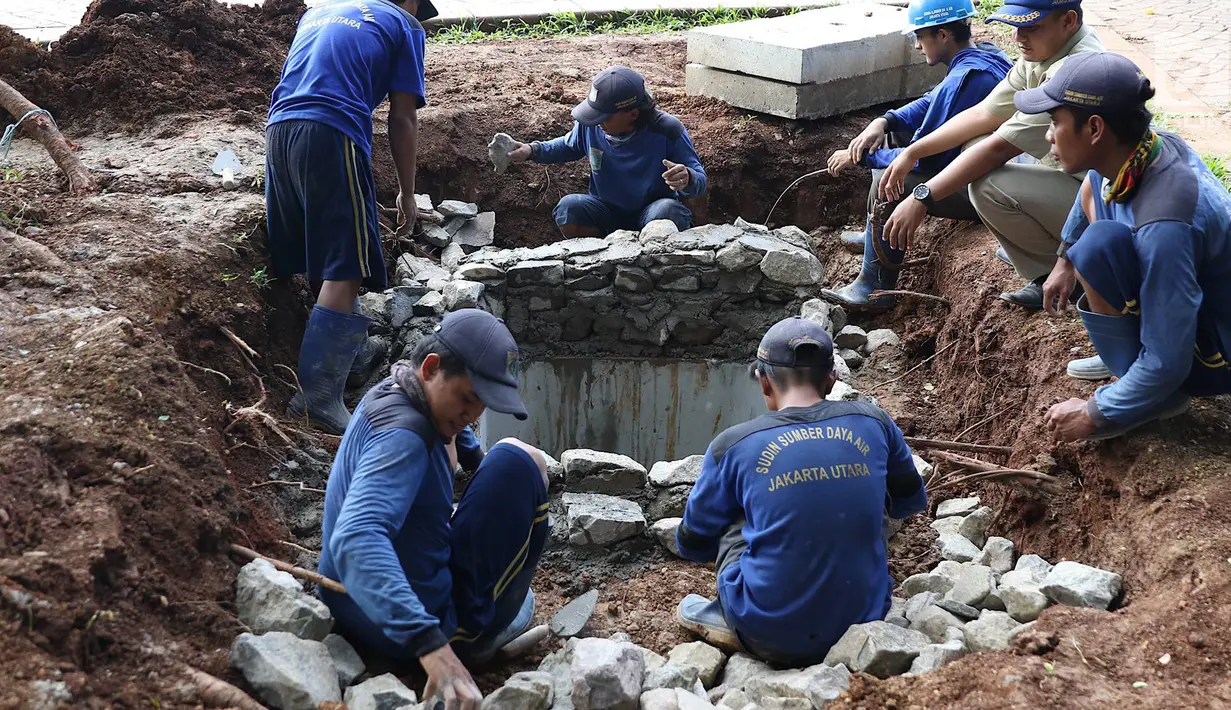 Petugas menyelesaikan pembuatan sumur resapan di kawasan Monas, Jakarta, Selasa (26/2). Pemkot Jakarta Pusat akan membangun 1.000 sumur resapan yang tersebar di berbagai lokasi untuk menampung air hujan. (Liputan6.com/Immanuel Antonius)