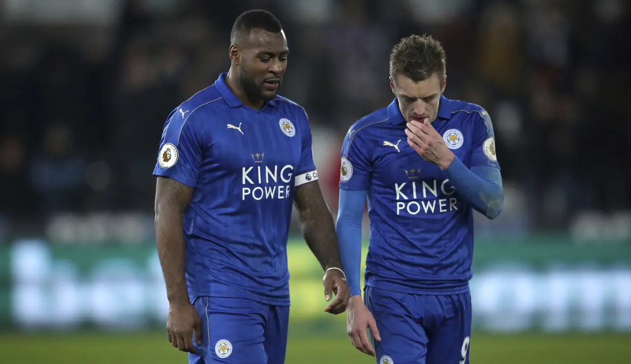 Dua punggawa Leicester City, Wes Morgan (kiri) dan Jamie Vardy meninggalkan lapangan usai kalah dari Swansea City  pada lanjutan Premier League di Liberty Stadium, Swansea, Wales,  (12/2/2017). Swansea menang 2-0. (Nick Potts/PA via AP)