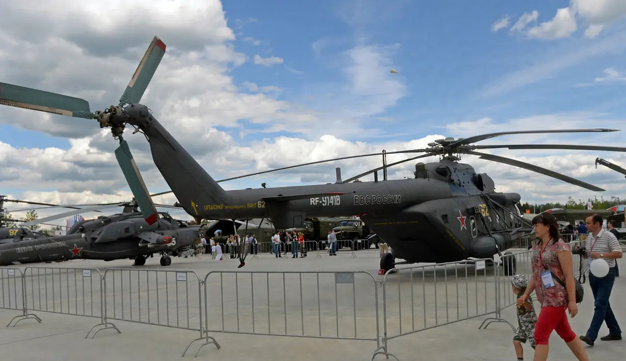 Pengunjung berjalan melewati sebuah helikopter militer Rusia MI - 8 di Kubinka, Moskow, Rusia, (17/6/2015).  Inilah bentuk utuh dari helikopter MI - 8. (AFP PHOTO/Vasily Maximov)