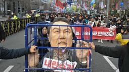 Dalam aksinya, para pengunjuk rasa juga membawa poster bergambar Presiden Yoon Suk Yeol yang terborgol dan terpenjara. (ANTHONY WALLACE/AFP)