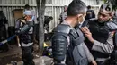 Personel Brimob bersiap mengenakan perlengkapan pelindung diri di Kawasan Bundaran HI, Jakarta, Selasa (13/10/2020). Sebanyak kurang lebih 12 ribu personel gabungan TNI, Polri dan Pemprov DKI Jakarta diterjunkan mengawal aksi tolak Undang-Undang Cipta Kerja Omnibus Law. (Liputan6.com/Faizal Fanani)