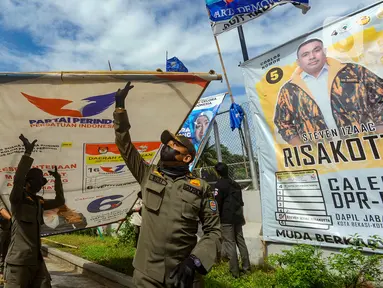 Petugas gabungan yang terdiri dari Satpol PP, Polresta Depok, dan Panwaslu menertibkan alat peraga kampanye (APK) Pemilu 2024 di Jalan Margonda Raya, Kota Depok, Jawa Barat, Rabu (24/1/2024). (merdeka.com/Arie Basuki)