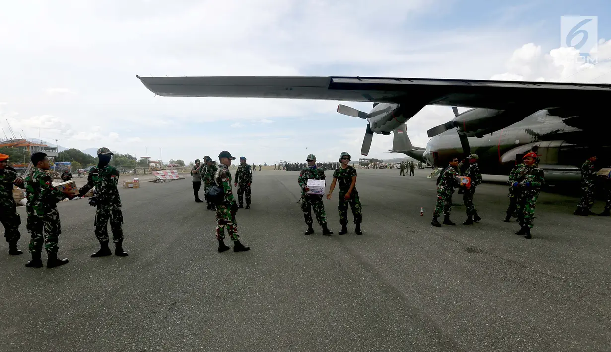 Prajurit TNI mendistribusikan bantuan logistik yang tiba di Bandara Mutiara Sis Al-Jufri, Palu, Sulawesi Tengah, Minggu (7/10). Tentara AS membantu mendistribusikan dari landasan menuju bandara. (Liputan6.com/Fery Pradolo)