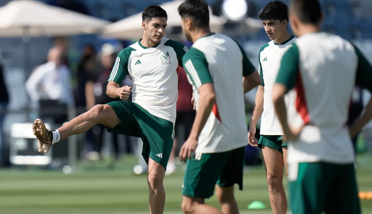 Pemain Meksiko Raul Jimenez (kiri) melakukan peregangan saat latihan jelang melawan Argentina pada pertandingan sepak bola Grup C Piala Dunia 2022 di Jor, Qatar, Jumat (25/11/2022). Meksiko akan menghadapi Argentina pada 27 November 2022. (AP Photo/Moises Castillo)