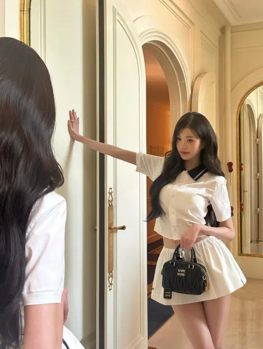 Wonyoung juga membawa mini bag hitam. Dengan riasan wajah seperti biasa mengenakan blush dan lipstik pink. Rambut panjangnya dibiarkan terurai tanpa poni. [@for_everyoung10]