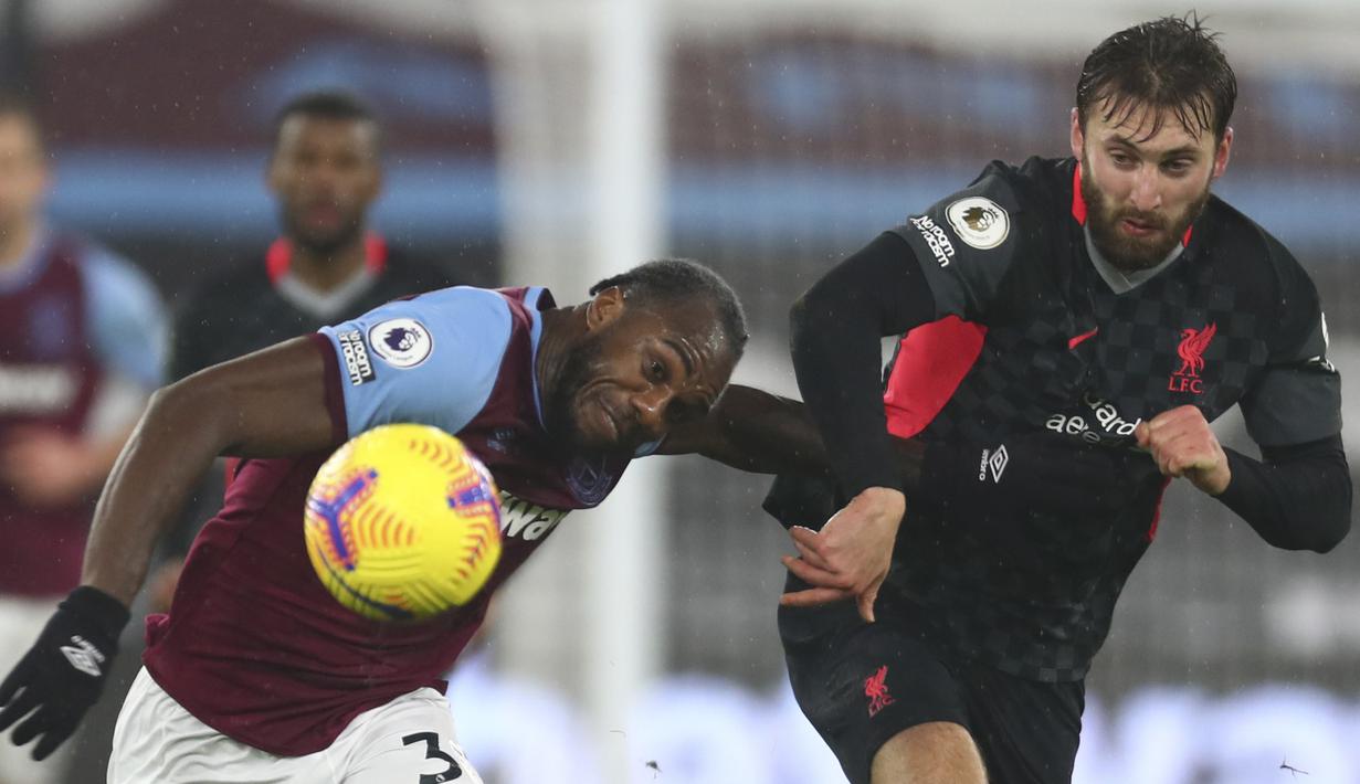 Gelandang West Ham United, Michail Antonio (kiri) berebut bola dengan bek Liverpool, Nathaniel Phillips pada lanjutan pekan ke-21 Liga Inggris 2020/2021 di London Stadium, Minggu (31/1/2021) malam WIB. West Ham dipaksa bertekuk lutut oleh Liverpool dengan skor 1-3. (Clive Rose/Pool via AP)