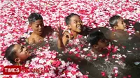 Siswa MI Darul Ulum mandi bunga mawar di Blumbang Macari, Jumat (13/4/2018). Mereka mengikuti prosesi Jamasan Sukmo Pusoko Rogo. (FOTO: Ferry/TIMES Indonesia)