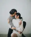 Dengan latar dinding putih polos, Tyas dan Tengku tampak serasi mengenakan sweater. [@@morden.co]
