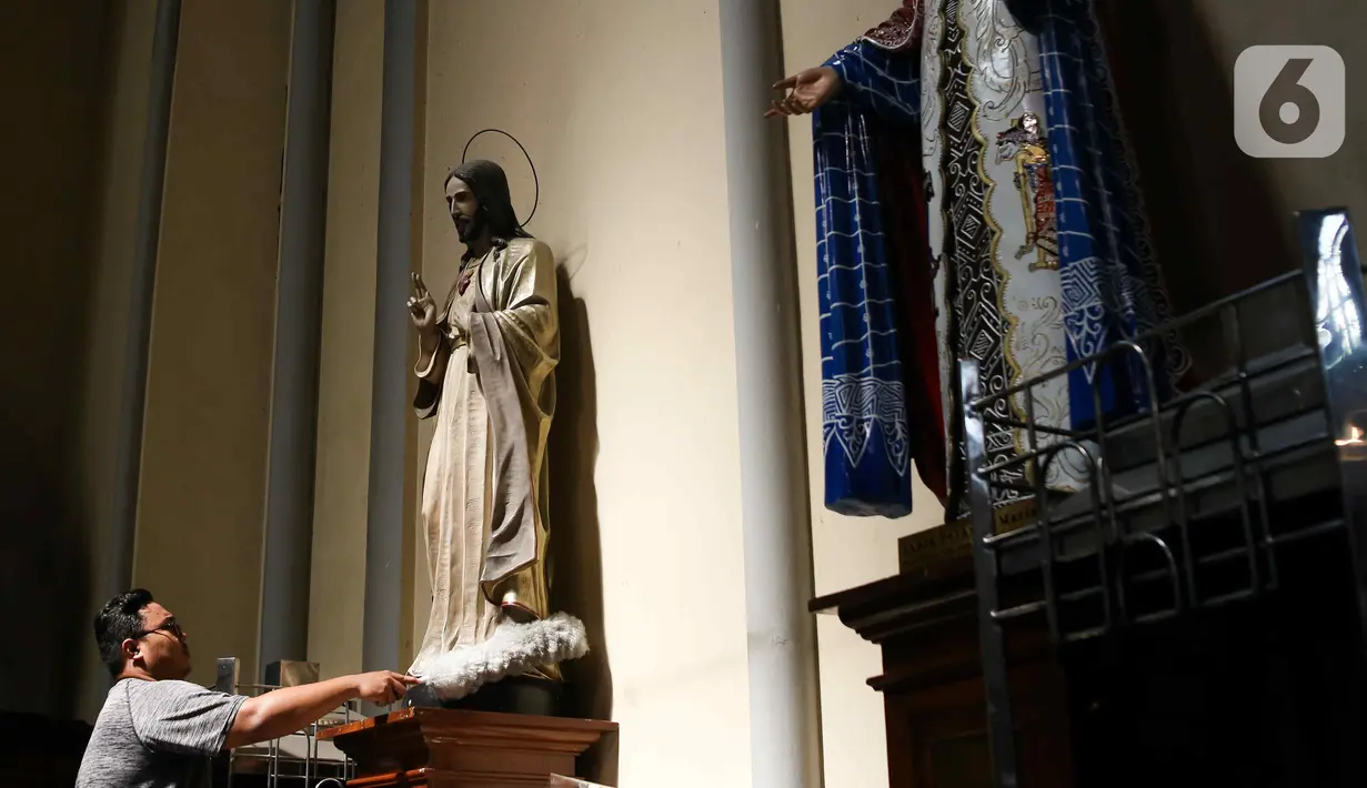 Pekerja membersihkan patung di Gereja Katedral, Jakarta, Kamis (21/12/2023). (Liputan6.com/Herman Zakharia)