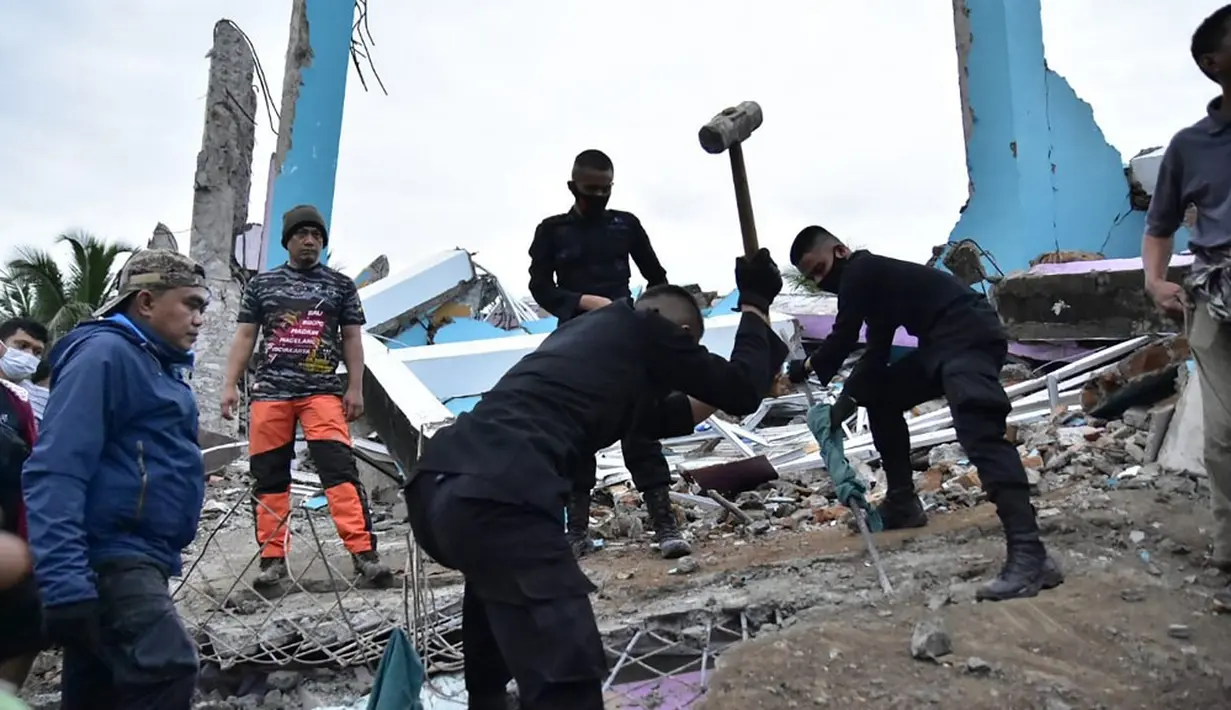 Tim penyelamat mencari korban usai gempa meruntuhkan Rumah Sakit Mitra Manakarra, Kota Mamuju, Sulawesi Barat, Indonesia, Jumat (15/1/2021). Sebanyak 20 pasien dan staf terjebak di bawah reruntuhan bangunan. (Firdaus/AFP)