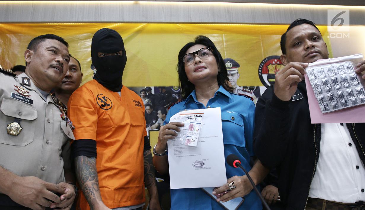  Kasat Narkoba, Kompol Vivick Tjangkung dan Aktor Tora Sudiro saat menunjukkan barang bukti obat dumolid sebanyak 30 butir di Mapolres Jakarta Selatan, Jumat (04/08). Tora dijerat dengan UU Psikotropika tahun 1997 pasal 62. (Liputan6.com/Herman Zakharia)