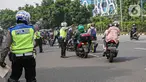 Petugas kepolisian lalu lintas memberhentikan pengendara motor saat Operasi Zebra Jaya 2020 di kawasan Cawang, Jakarta, Senin (26/10/2020). Operasi Zebra Jaya dilaksanakan pada 26 Oktober-8 November 2020 untuk menekan jumlah pelanggaran lalu lintas. (Liputan6.com/Faizal Fanani)
