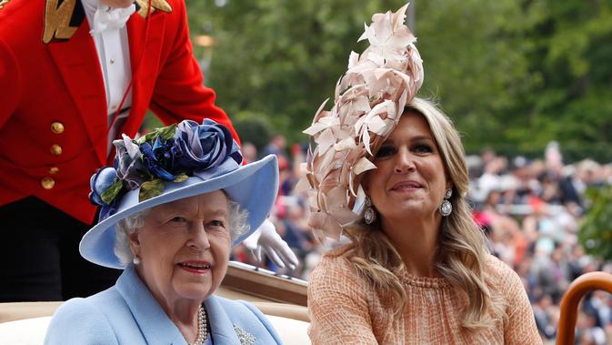Ratu Inggris Elizabeth II (kiri) dan Ratu Belanda Maxima mengenakan topi atau fascinator unik saat menghadiri ajang pacuan kuda Royal Ascot di Ascot, Inggris, Selasa (18/6/2019). Royal Ascot menjadi ajang bagi wanita Inggris untuk tampil dengan fascinator unik. (AP Photo/Alastair Grant)