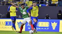 Cristiano Ronaldo dari Al Nassr (kanan) berusaha membawa bola saat bertanding melawan Al Ettifaq selama pertandingan Liga Pro Saudi di Stadion Mrsool Park, di Riyadh, Arab Saudi, Minggu (22/1/2023). Diketahu, Ronaldo dibeli Al Nassr senilai 200 juta euro atau setara dengan 3,26 triliun per musim. (AP Photo)