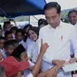 Presiden Joko Widodo membagikan buku ke anak-anak pengungsi korban gempa di Universitas Darussalam, Kecamatan Tulehu, Kabupaten Maluku Tengah (29/10/2019). Jokowi mengingatkan bahwa Indonesia berada di kawasan cincin api sehingga potensi gempa dan tsunami selalu ada.  (Liputan6.com/Biro Pers)