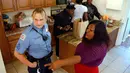 Sersan Jessica Hawkins (kiri) saat berbincang dengan wanita transgender di sebuah penampungan transgender, AS, Senin (10/10). Jessica Hawkins merupakan satu-satunya polisi transgender di AS. (REUTERS/ Jonathan Ernst)