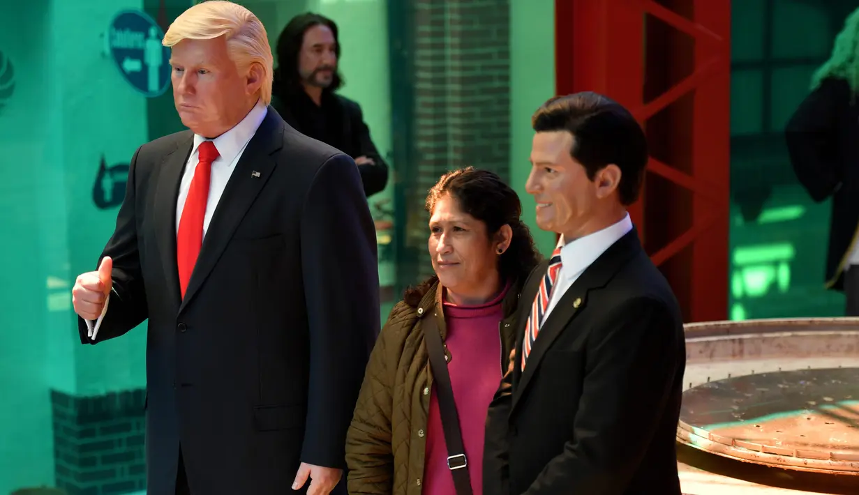 Seorang pengunjung berpose di dekat Patung lilin Presiden AS Donald Trump di Museum Lilin di Mexico City, Selasa (31/1). (AFP PHOTO / Yuri CORTEZ)
