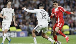 Gelandang Jerman Bayern Munich #10, Jamal Musiala (kanan), dan bek Inggris Real Madrid #12, Trent Alexander-Arnold, berebut bola selama pertandingan leg pertama perempat final Liga Champions UEFA antara Real Madrid dan Bayern Munchen di Stadion Santiago Bernabeu di Madrid pada 8 April 2026. (Oscar DEL POZO/AFP)