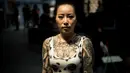 Seorang wanita berpose memperlihatkan tato diseluruh tubuhnya saat acara Langfang Internasional Tattoo di Hebei, China (29/5/2016). (AFP PHOTO / FRED Dufour)