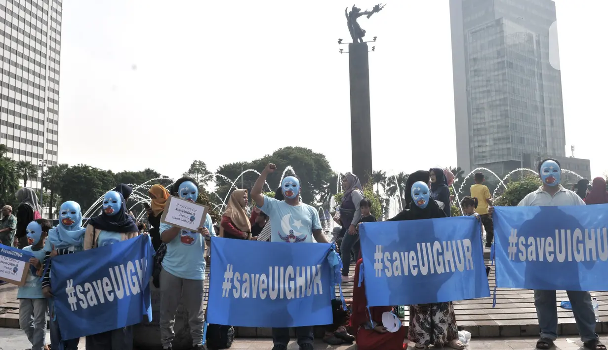 Warga mengenakan topeng bendera Turkestan Timur dan membentangkan poster saat menggelar Aksi Save Uighur selama Hari Bebas Kendaraan Bermotor (HBKB) atau Car Free Day (CFD), Jakarta, Minggu (22/12/2019). (merdeka.com/Iqbal S. Nugroho)
