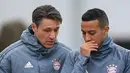 Pelatih Bayern Munchen, Niko Kovac (kiri) berbincang dengan gelandang Thiago Alcantara selama sesi latihan tim di Munich, Jerman selatan (12/3). Pada leg pertama Munchen berhasil menahan imbang Liverpool 0-0 di Anfield Stadium. (AFP Photo/Christof Stache)