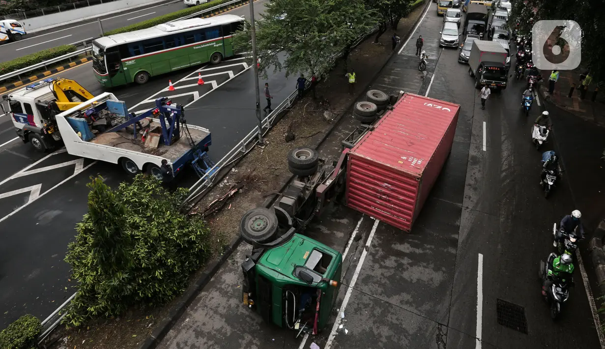 Petugas melakukan evakuasi Kontainer yang terguling di Jalan S Parman, Jakarta Barat, Senin (4/5/2020). Tidak ada korban jiwa dalam kecelakaan tersebut, namun kecelakaan tersebut membuat lalin dijalan itu terimbas kemacetan yang cukup panjang. (Liputan6.com/Johan Tallo)