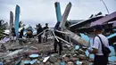 Tim penyelamat membuang puing-puing saat mencari korban dari Rumah Sakit Mitra Manakarra yang runtuh akibat gempa, Kota Mamuju, Sulawesi Barat, Indonesia, Jumat (15/1/2021). Sebanyak 20 pasien dan staf terjebak di bawah reruntuhan bangunan. (Firdaus/AFP)