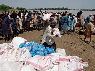 Korban banjir saat menerima bantuan Yayasan Edhi di Distrik Ghotki, Sindh Pakistan, Rabu (7/9/2022).Pekerja bantuan memperingatkan kurangnya pasokan air minum bersih yang menyebabkan peningkatan penyakit di Pakistan, karena korban tewas akibat banjir melewati 1.200 jiwa.(AP Photo/Fareed Khan)