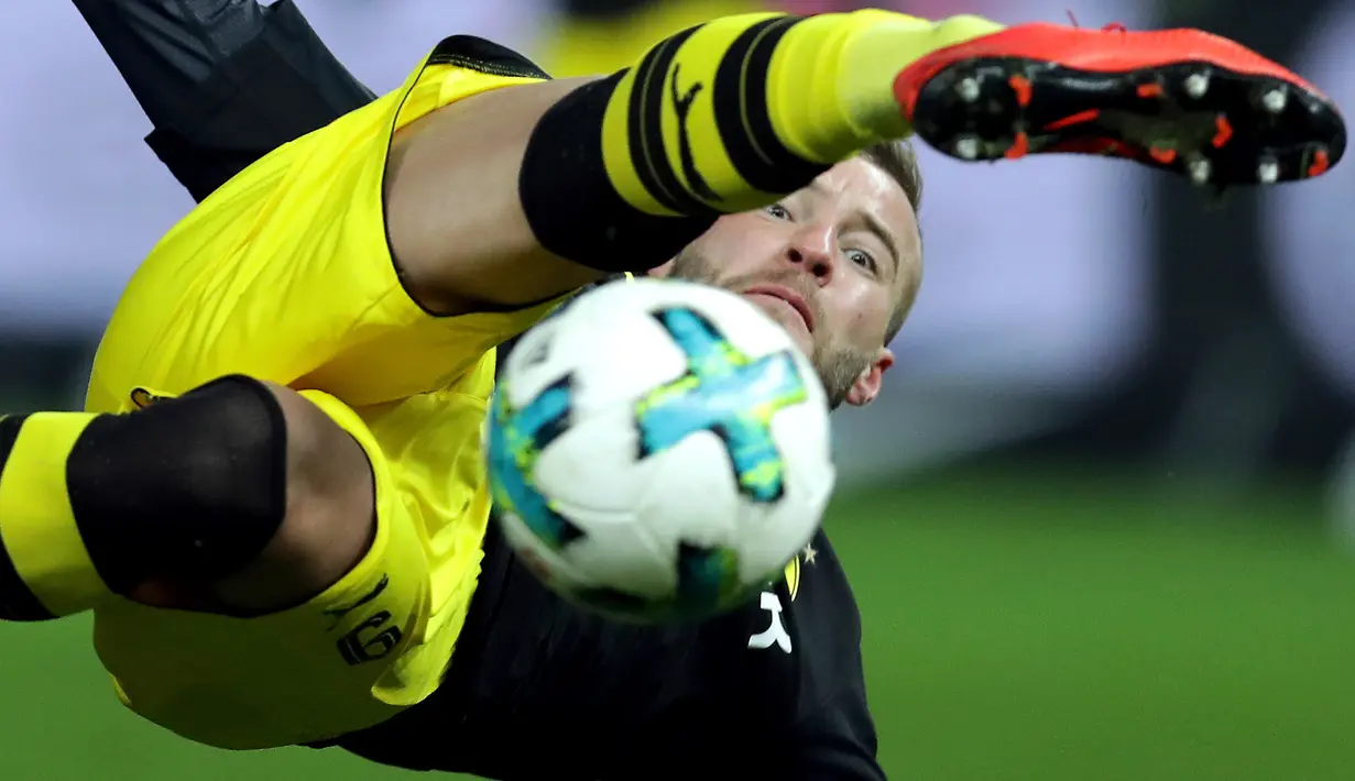Pemain Borussia Dortmund, Andrey Yarmolenko terjatuh saat merebut bola dari pemain Hertha Berlin dalam lanjutan Bundesliga di Olympiastadion Berlin, Sabtu (20/1). Hasil imbang 1-1 mengakhiri duel antara Hertha Berlin vs Dortmund. (AP Photo/Michael Sohn)