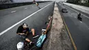 Longboarder dan penderita kanker Nongluck Chairuettichai, juga dikenal sebagai Jeab, mengenakan bantalan lutut saat latihan di Bangkok, 9 September 2020. Melaju di jalan raya yang kosong, kegiatan ini dilakukan sebagai jalan pemulihan dari kanker payudara yang dideritanya. (Lillian SUWANRUMPHA/AFP)