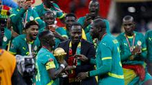 Pelatih kepala Senegal, Pape Thiaw (C), dan tim merayakan kemenangan dengan trofi setelah memenangkan pertandingan final Piala Afrika (CAN) 2025 melawan Maroko di Stadion Pangeran Moulay Abdellah di Rabat, Senin (19-1-2026) dini hari WIB. (Abdel Majid BZIOUAT/AFP)