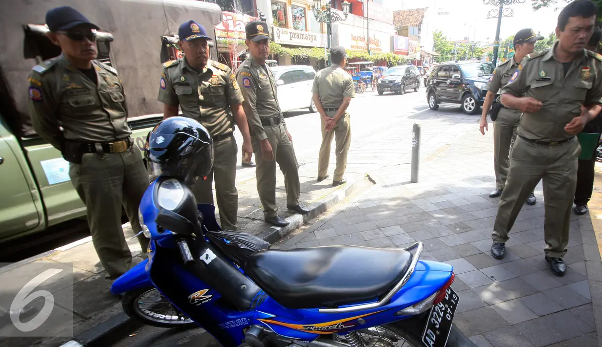 Petugas Satpol PP berjaga di kawasan pendestrian Malioboro, Yogyakarta, Selasa (19/4). Petugas memberikan surat peringatan dan mengambil kartu identitasnya yang di tahan di KUPT Malioboro. (Liputan6.com/Boy Harjanto)