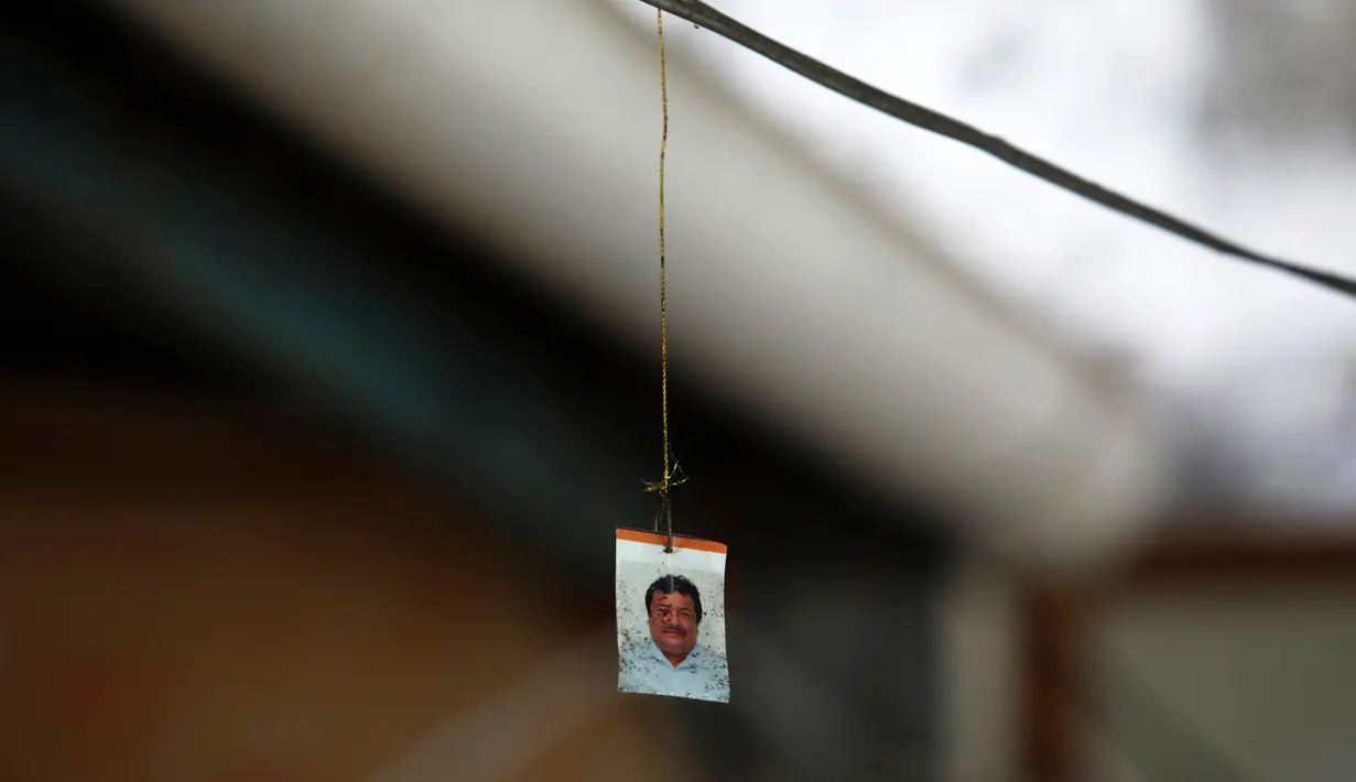 Potret wartawan Leobardo Vazquez yang tergantung di kabel tempat ia ditemukan tewas di depan rumahnya di Gutierrez Zamora, Meksiko (22/3). Vazquez ditemukan tewas terbunuh di dekat kios taco miliknya. (AP/Felix Marquez)