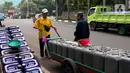 Pedagang mendorong gerobak drigen untuk di isi air bersih di Kembangan, Jakarta, Rabu (13/7/2022). Air bersih yang dijual seharga 5 ribu per drigen tersebut untuk memenuhi kebutuhan air bersih bagi warga sekitar kawasan tersebut. (Liputan6.com/Angga Yuniar)