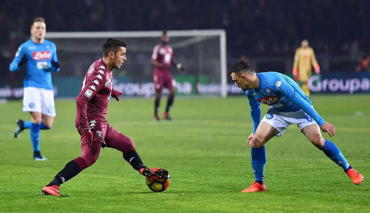 Striker Torino, Iago Falque, berusaha melewati bek Napoli, Mario Rui, pada laga Serie A di Stadion Olimpico Grande Torino, Sabtu (16/12/2017). Napoli menang 3-1 atas Torino. (AP/Alessandro Di Marco)