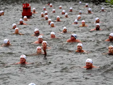 Orang-orang mengambil bagian dalam kompetisi berenang Natal tahunan di sungai Vltava, ibu kota Republik ceko, Praha, Rabu (26/12). Dalam menyemarakkan Natal, para peserta mengikuti lomba renang di sungai bersuhu dingin. (AP/Petr David Josek)