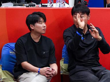 Pelatih Timnas Indonesia, Shin Tae-yong (kanan), berbincang dengan penerjemahnya Jeong Seok-seo, saat menonton laga Grup H Piala Dunia FIBA 2023 antara Kanada melawan Latvia di Indonesia Arena, Senayan, Jakarta, Selasa (29/08/2023). (Bola.com/Bagaskara Lazuardi)