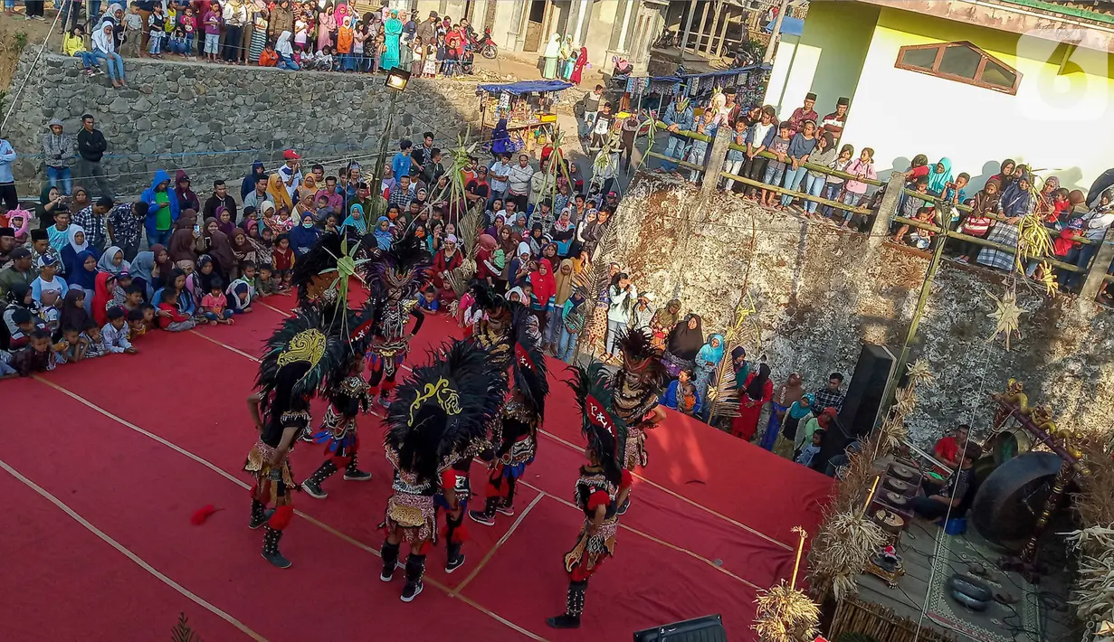 Warga menyaksikan aksi tarian kuda lumping para penari komunitas lima gunung di Desa Mantran Wetan, Kabupaten Magelang, Jumat  (11/10/2019). Pertunjukan ini bagian dari Perayaan Saparan sebagai wujud syukur warga di desa itu. (Liputan6.com/Gholib)
