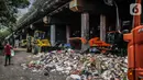 Petugas PPSU menggunakan kendaraan alat berat untuk mengangkut tumpukan sampah di kolong tol Wiyoto Wiyono, Tanjung Priok, Jakarta, Selasa (5/11/2019). Kolong Tol Tol Wiyoto-Wiyono berubah menjadi tempat penampungan sampah rumah tangga dari tiga kelurahan di kawasan itu. (Liputan6.com/Faizal Fanani)