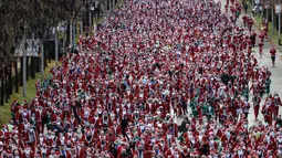 Lebih dari 10 ribu orang yang mengenakan kostum Santa Claus, termasuk anak-anak, ikut serta dalam lomba lari sejauh 4,5 kilometer. Tampak dalam foto, ribuan pelari yang mengenakan kostum Santa Claus berpartisipasi dalam edisi ke-14 lomba Santa Claus, sebuah lari santai sejauh 4,5 km melalui jalan-jalan Madrid pada Minggu 21 Desember 2025. (OSCAR DEL POZO/AFP)