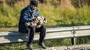 Imigran dan bayinya menunggu untuk menyeberang perbatasan Slovenia - Austria dari kota Sentilj, Selasa (3/11). Slovenia mengatakan kewalahan menghadapi arus ribuan migran yang melintasi wilayah negara itu untuk menuju Eropa barat. (AFP PHOTO/RENE GOMOLJ)