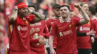 Pemain Liverpool, Dominik Szoboszlai (kiri) merayakan kemenangan timnya bersama Andrew Robertson setelah memastikan gelar juara Liga Inggris 2024/2025 di Anfield, Liverpool, Inggris, Minggu (27/04/2025) waktu setempat. (AFP/Paul Ellis)